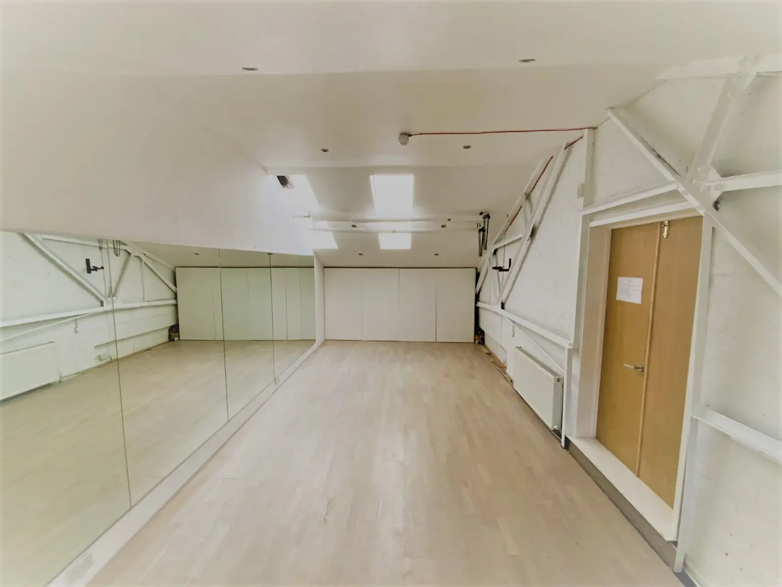 Studio 28 from the back — timber floor, full-height mirrors and natural light