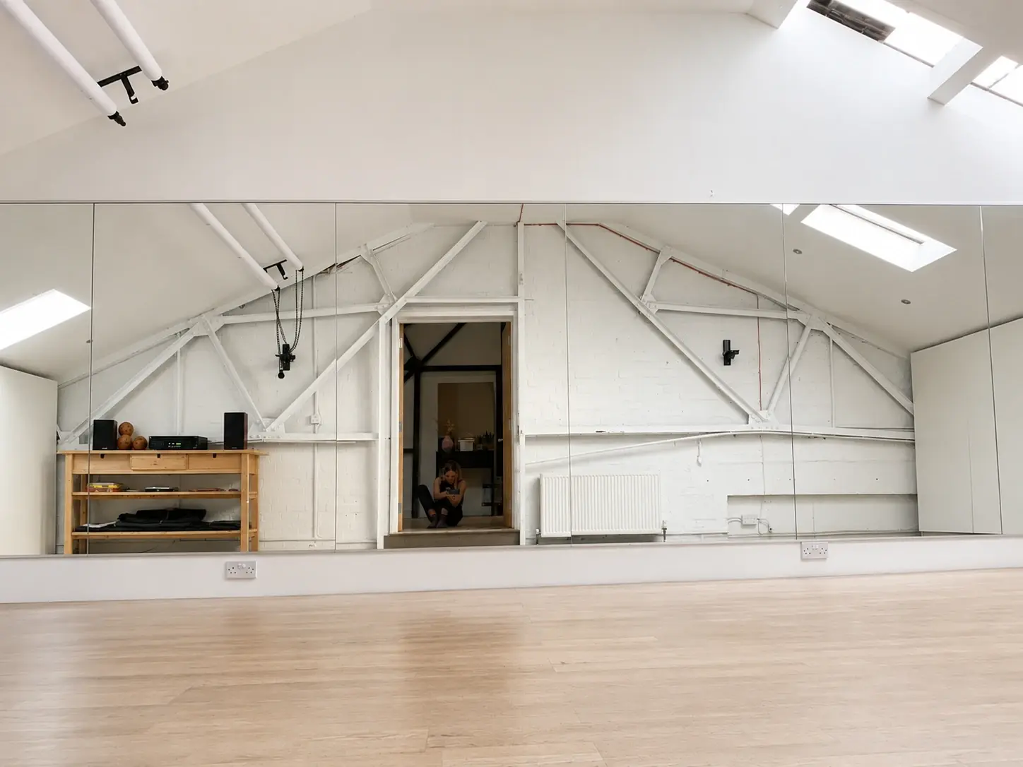 Studio 28 from the front door — timber floor stretching to the mirrors